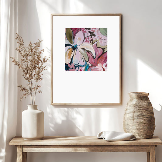 Contemporary floral abstract paper art print. Colourful modern design in pinks, browns, turquoise and green. Abstract linear flower petals and organic flowing shapes. Paper art print framed in an natural frame and hanging on a modern neutral living room wall.