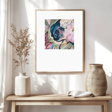 Contemporary colourful abstract floral paper art print with a big white border around it. Framed in a natural frame and hanging in a neutral modern living room.
