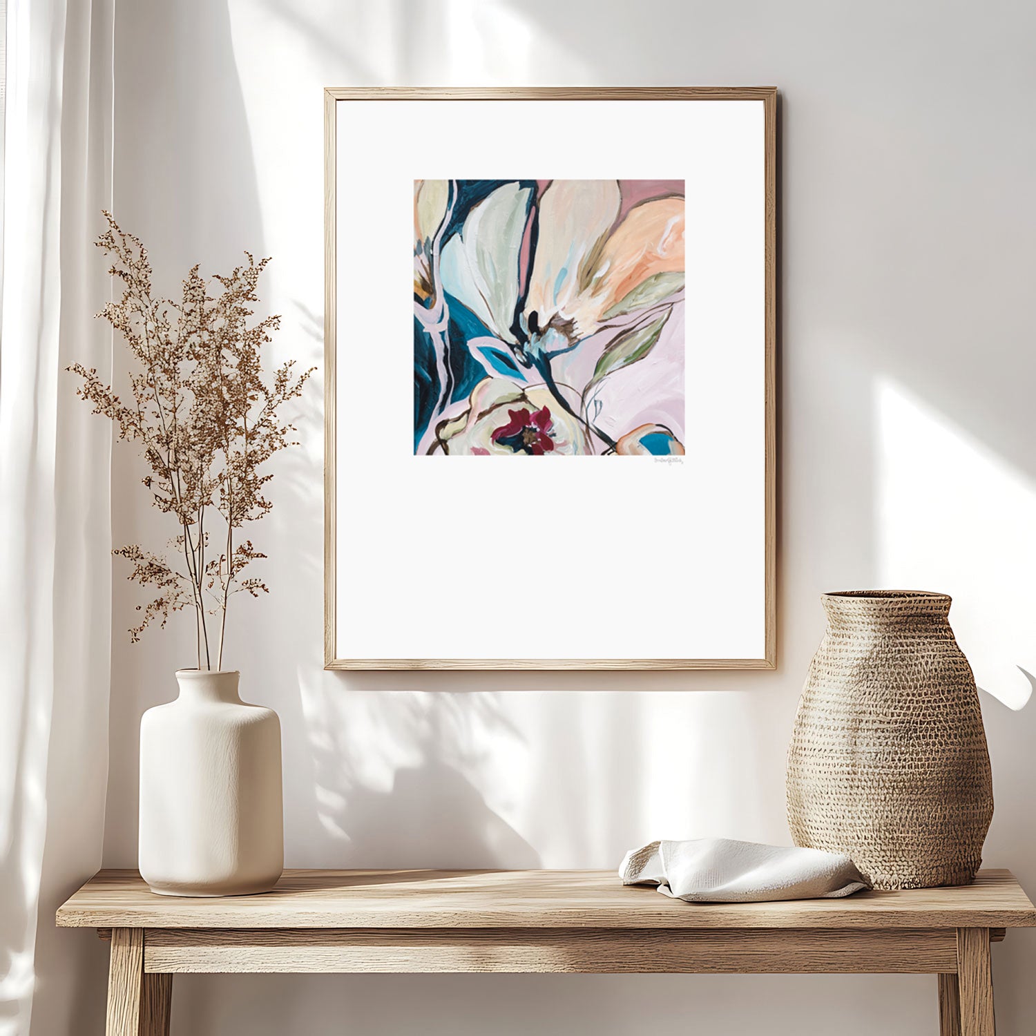 Stunning modern eclectic flower abstract art print in soft pinks and turquoise. Bohemian inspired style of design of linear flower petal shapes in a fun flowing design. Big white border around the square shaped colourful design. Framed in a natural frame and hanging in a boho inspired living room.