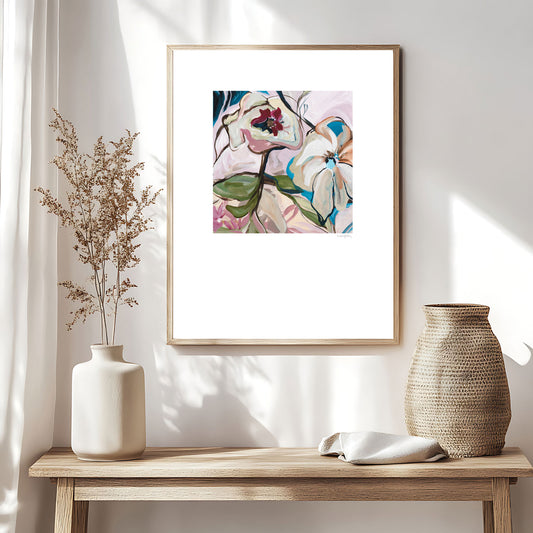 Stunning modern eclectic flower abstract art print in soft pinks and turquoise. Bohemian inspired style of design of linear flower petal shapes in a fun flowing design. Big white border around the square shaped colourful design. Framed in a natural frame and hanging in a boho inspired living room.