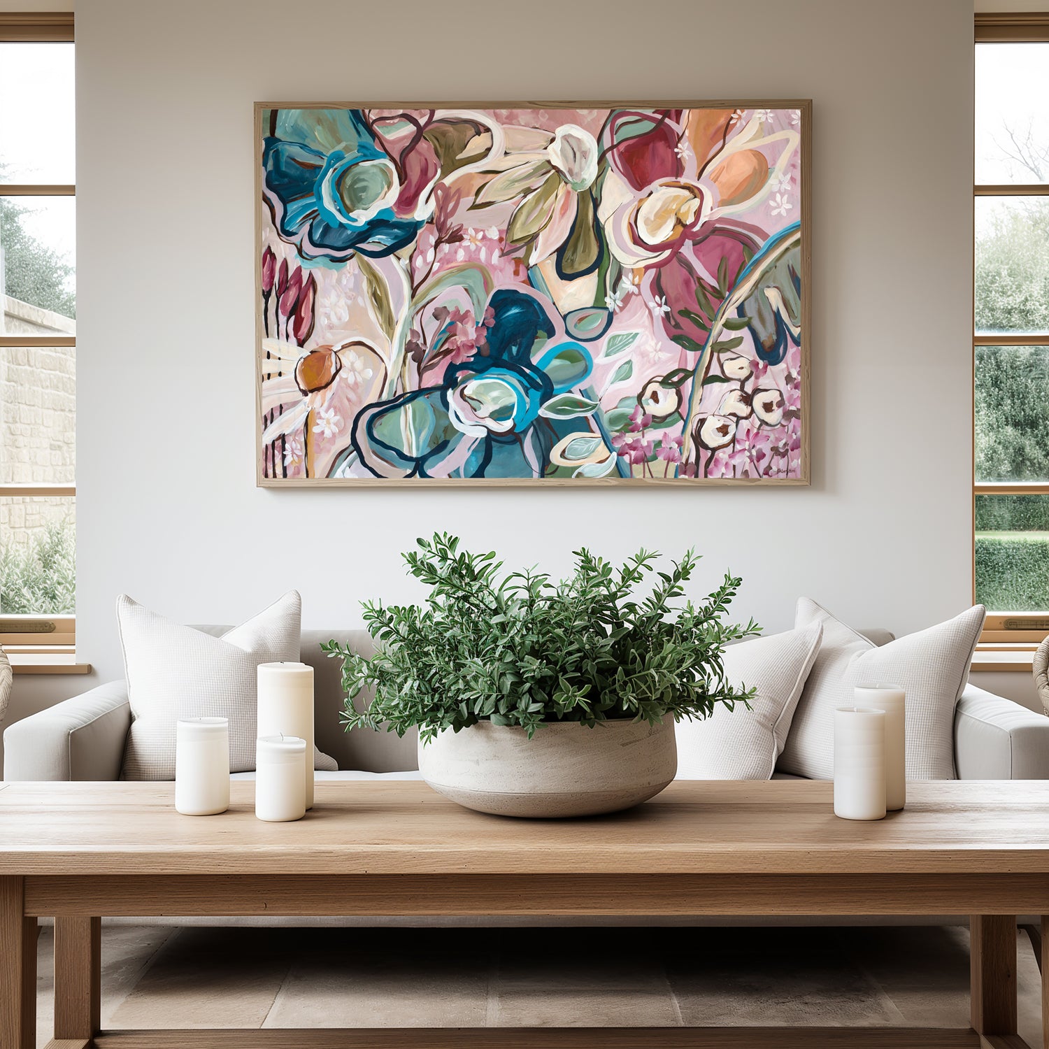 Modern abstract flower fine art canvas print with dark blue and pink flowers. With a natural frame hanging against a wall in a neutral modern living room.