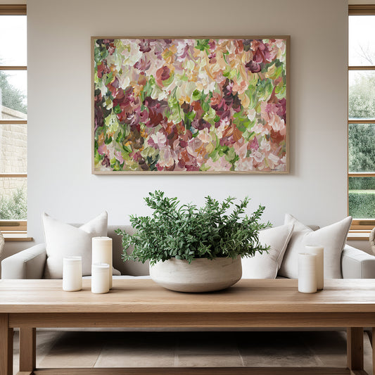 Abstract flower  fine art canvas print in a modern style with autumn colours of orange, burgundy, ochre and green. Hanging in a living room with a natural frame and white lounge suite underneath.