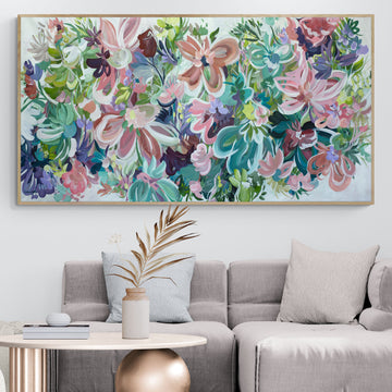 Large colourful abstract flower painting with a natural frame, hanging in a neutral beige lounge room