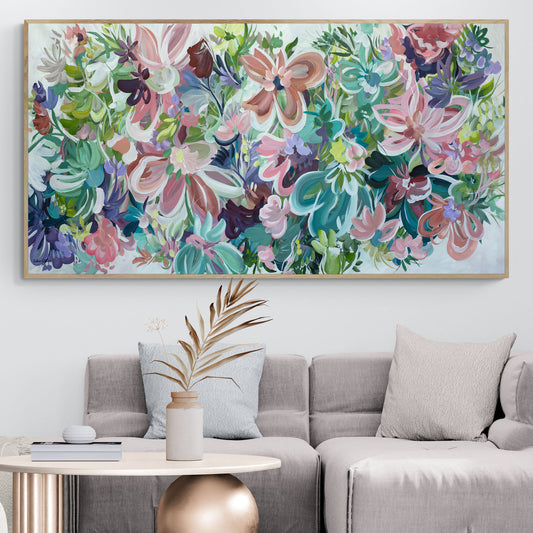 Large colourful abstract flower painting with a natural frame, hanging in a neutral beige lounge room