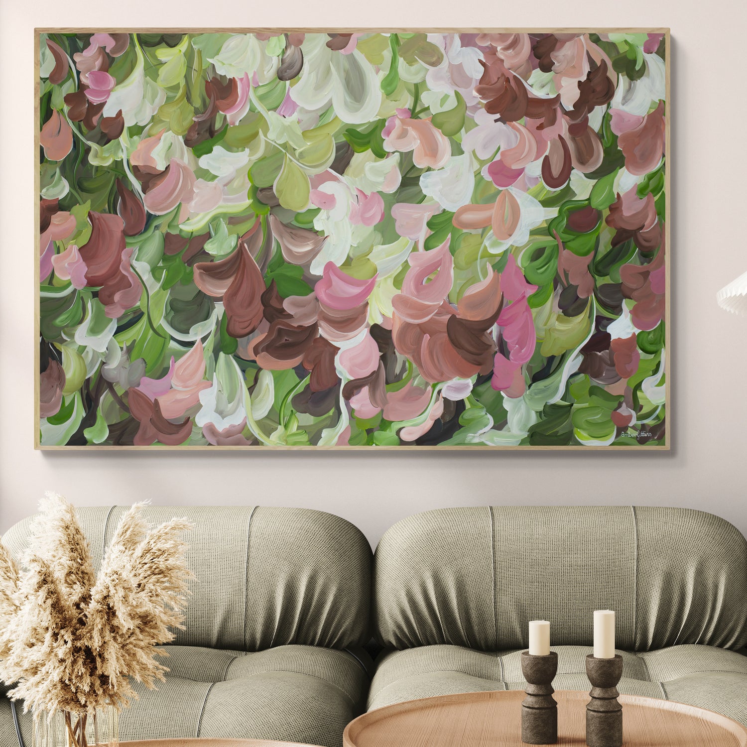 Modern abstract painting of pink, brown and green organic shapes hanging in a living room.