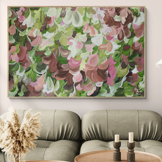 Modern abstract painting of pink, brown and green organic shapes hanging in a living room.