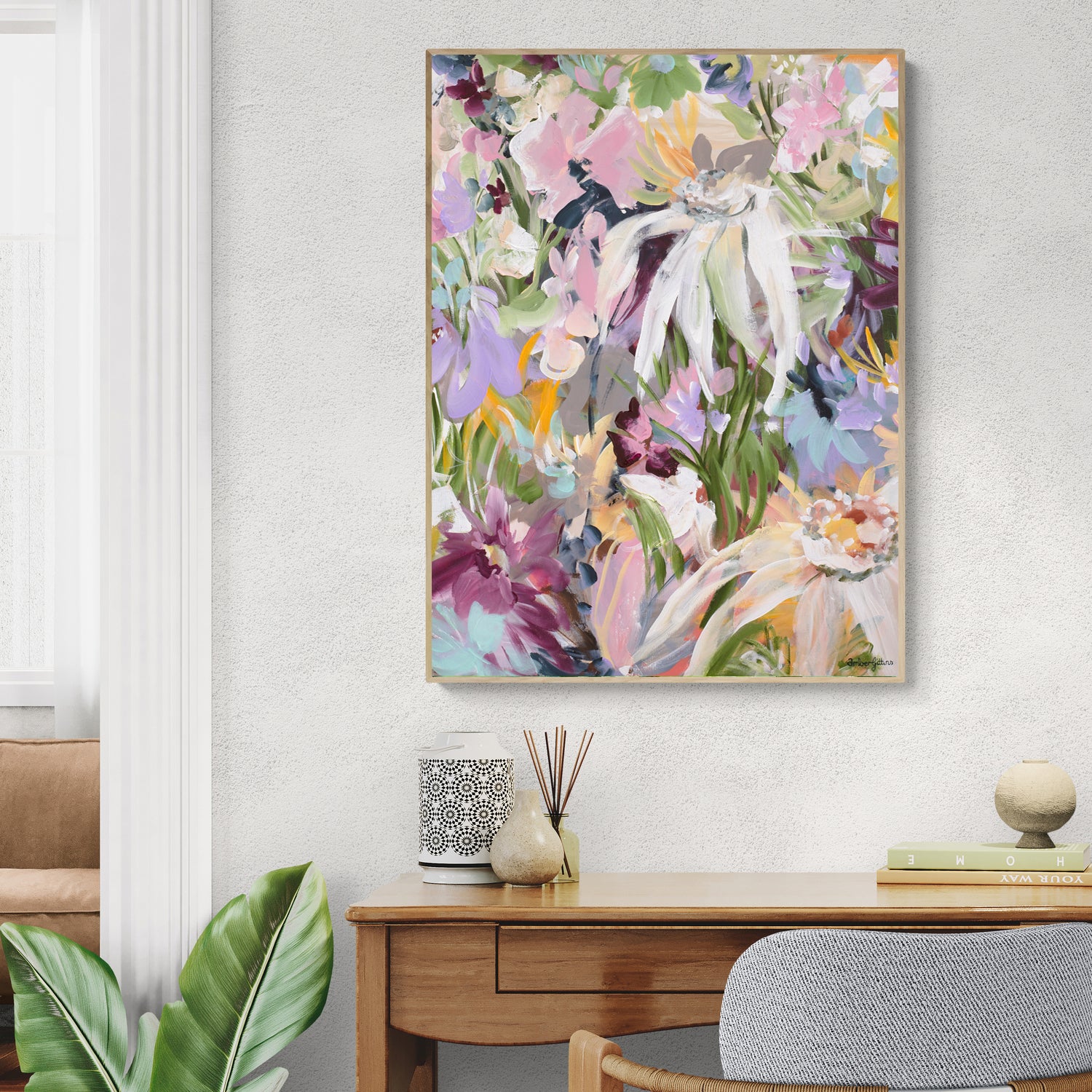 Pretty feminine abstract flower canvas wall art print in pastel shades of pink, purple, spearmint and green. Modern and colourful flower garden print in a natural frame. Hanging in a living room.