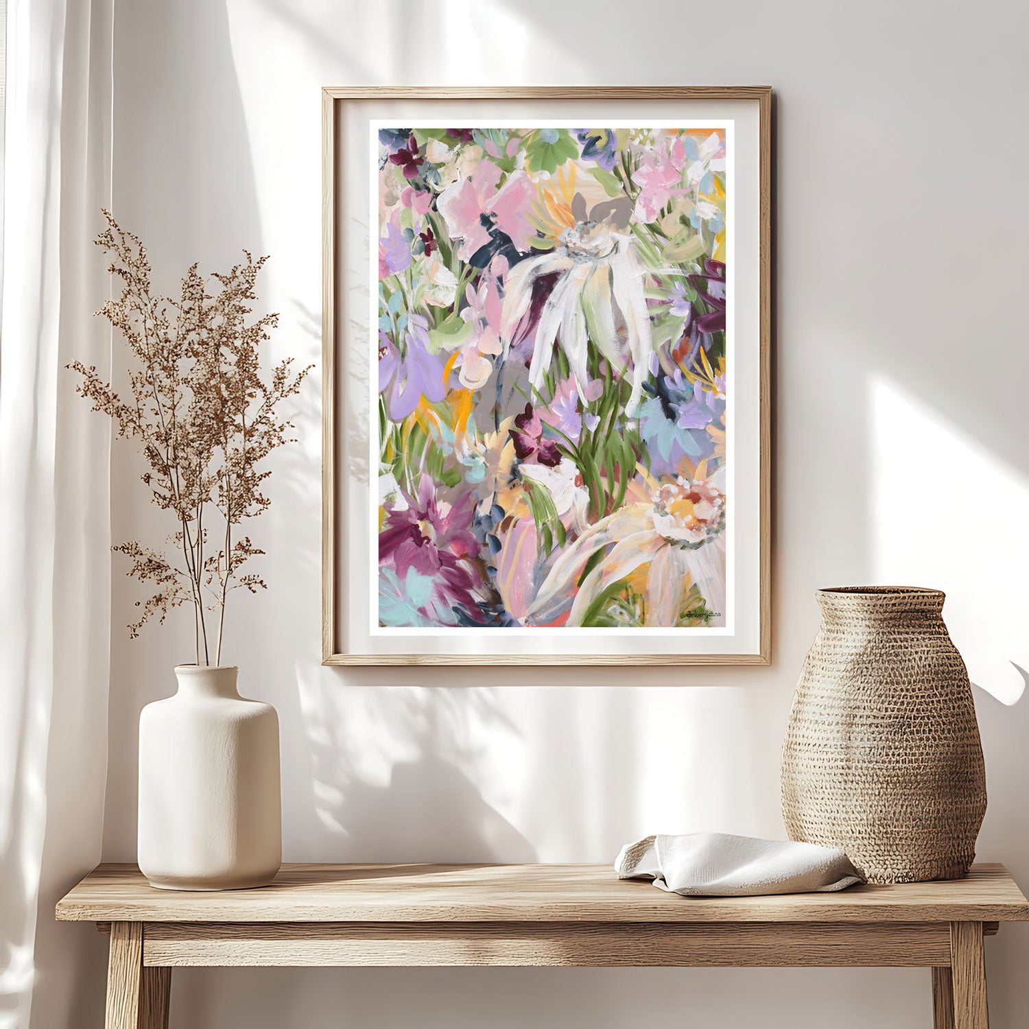 Pretty feminine abstract flower wall art print in pastel shades of pink, purple, spearmint and green. Modern and colourful flower garden print in a natural frame. Hanging in a living room.