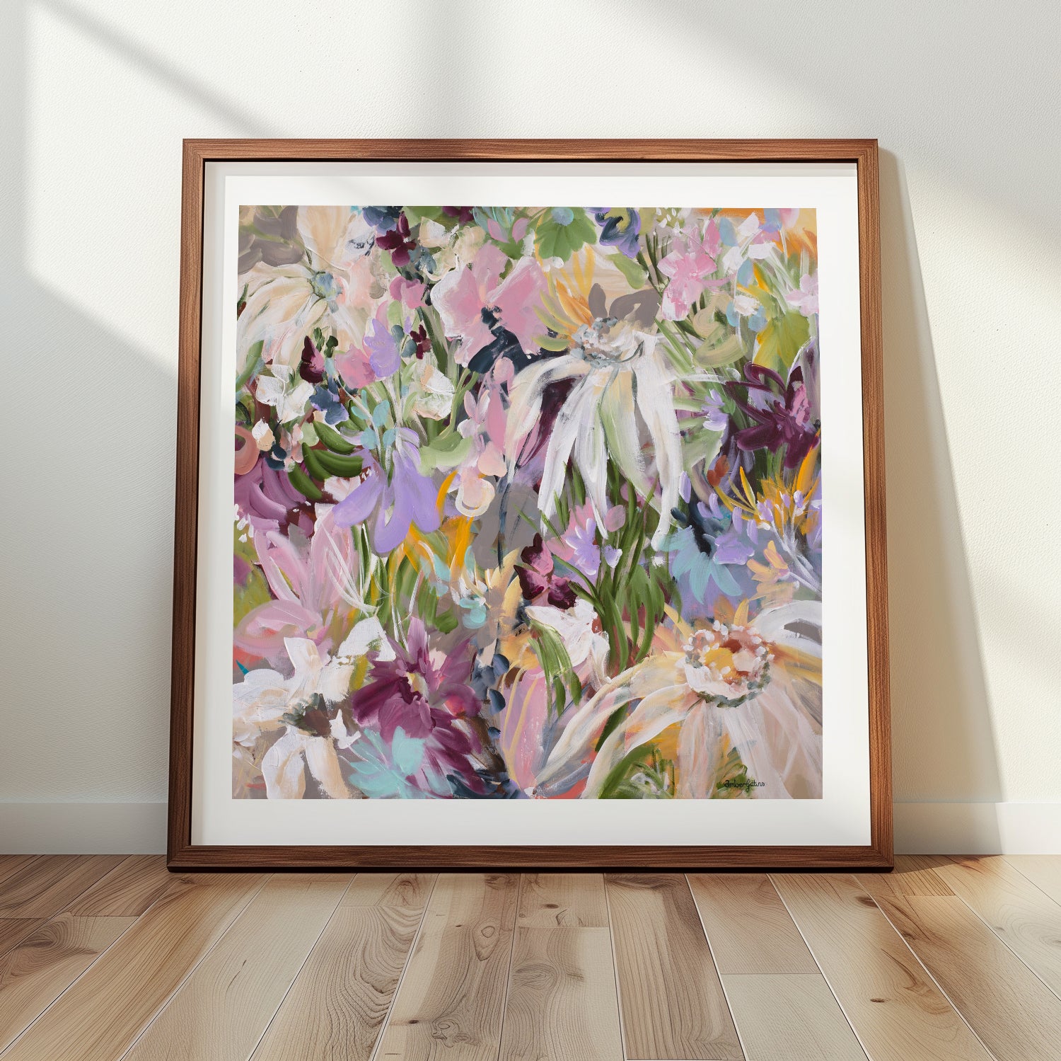 Framed colourful floral art print on a wall with wooden floor