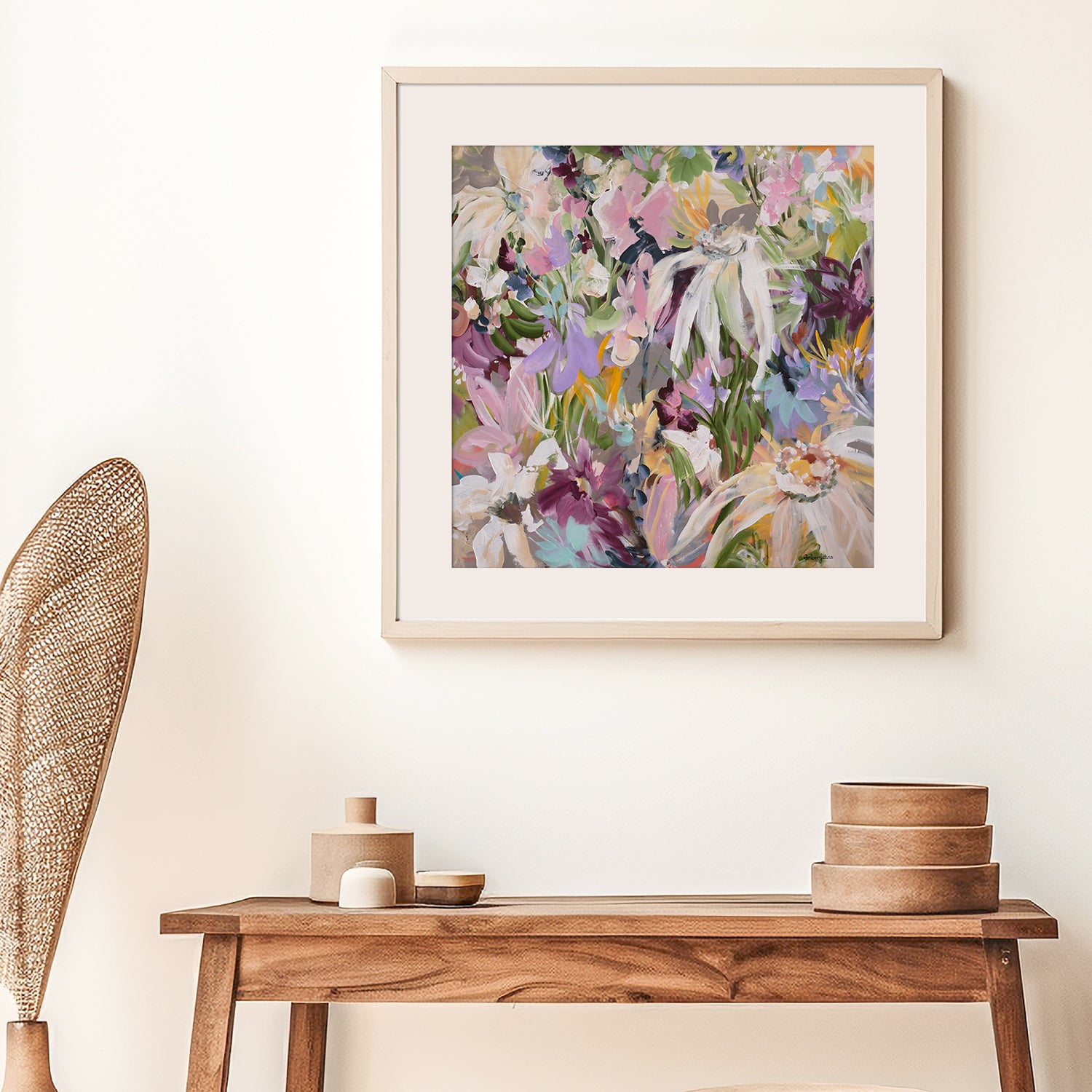 Framed floral art print on a wall above a wooden console table with decorative items.