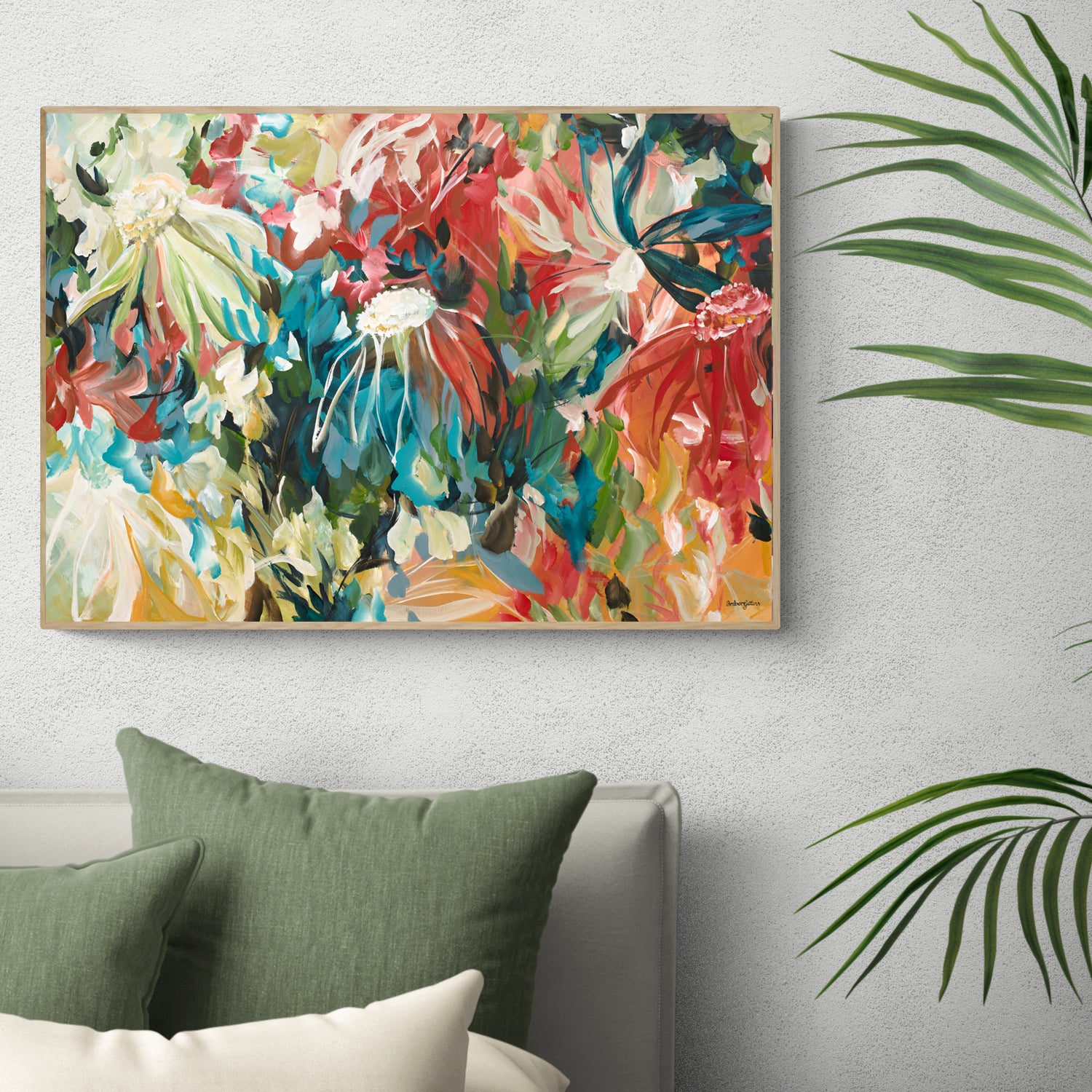 Modern abstract flower art print in a colourful and bright palette of reds, turquoise, greens and warm yellows. Expressive and contemporary style of artwork. Framed in a natural frame hanging against a living room wall.