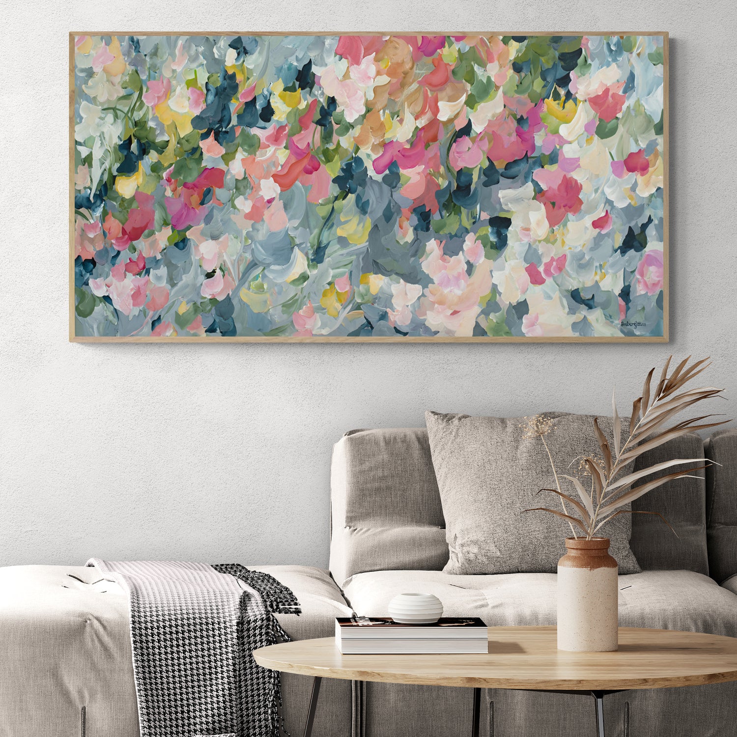 Contemporary impressionist style abstract art print inspired by flower petals and organic shapes of a flower garden. Modern colour palette of blue grey, pink and green. Framed in a natural frame hanging in a neutral modern lounge room.