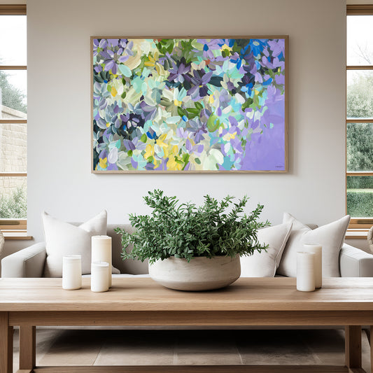 Modern impressionist style abstract flower art print in purple and yellow and white. Hanging against a living room wall with a natural frame.