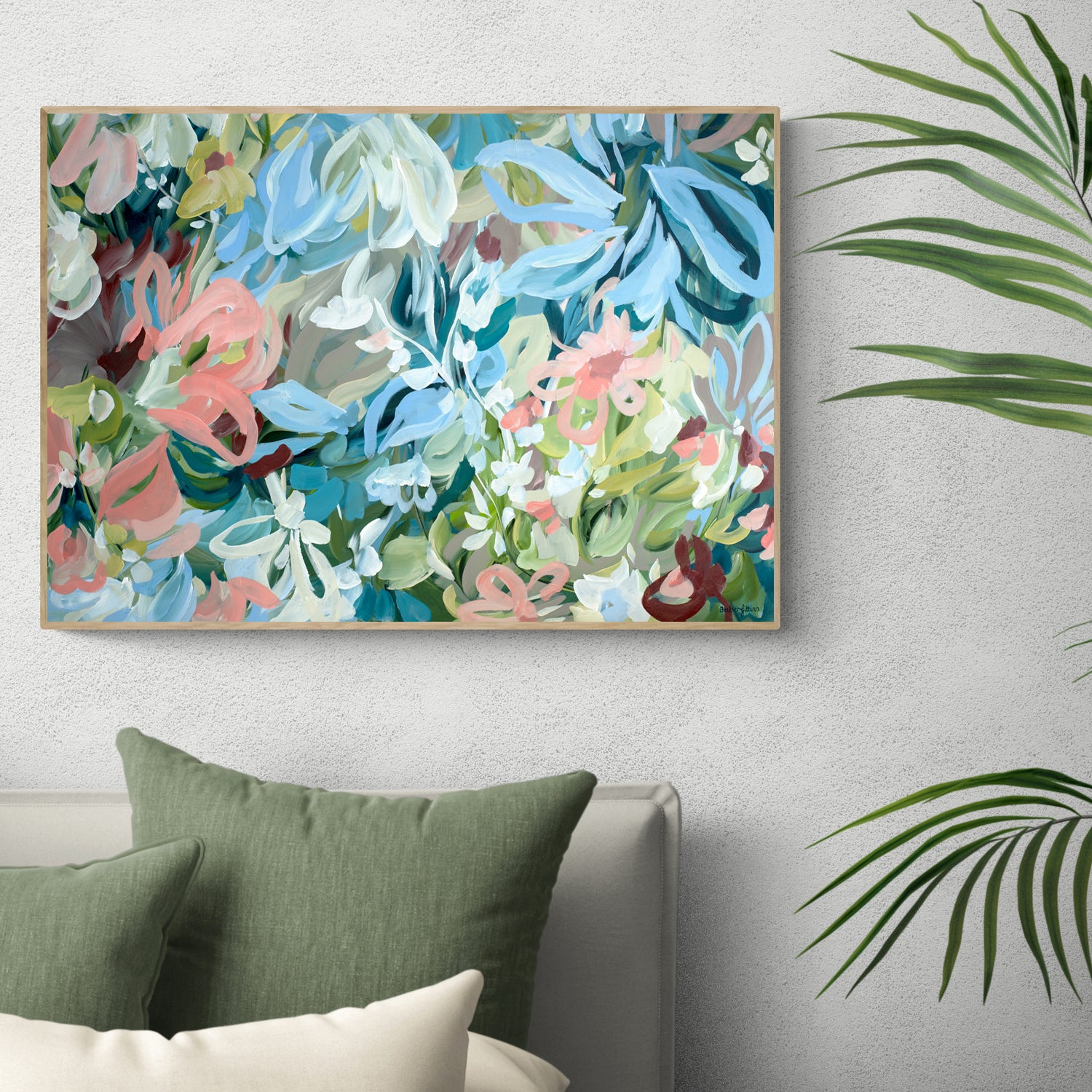 Framed wall art print of a modern, colourful abstract flower garden in pastel shades of pink, baby blue, green and turquoise. Hanging on a living room wall.