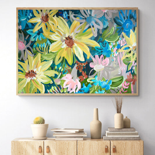 Colourful abstract flower wall art canvas print with big yellow sunflowers hanging on living room wall in a natural frame