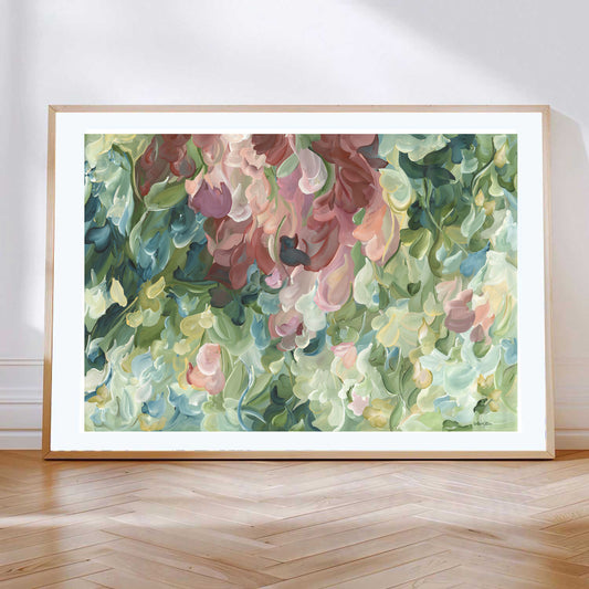 Modern impressionist abstract wall art print of organic round shapes layered like leaves and flower petals falling. Soft pastel green and pinks with pale yellow modern colour palette. Framed in a natural frame.