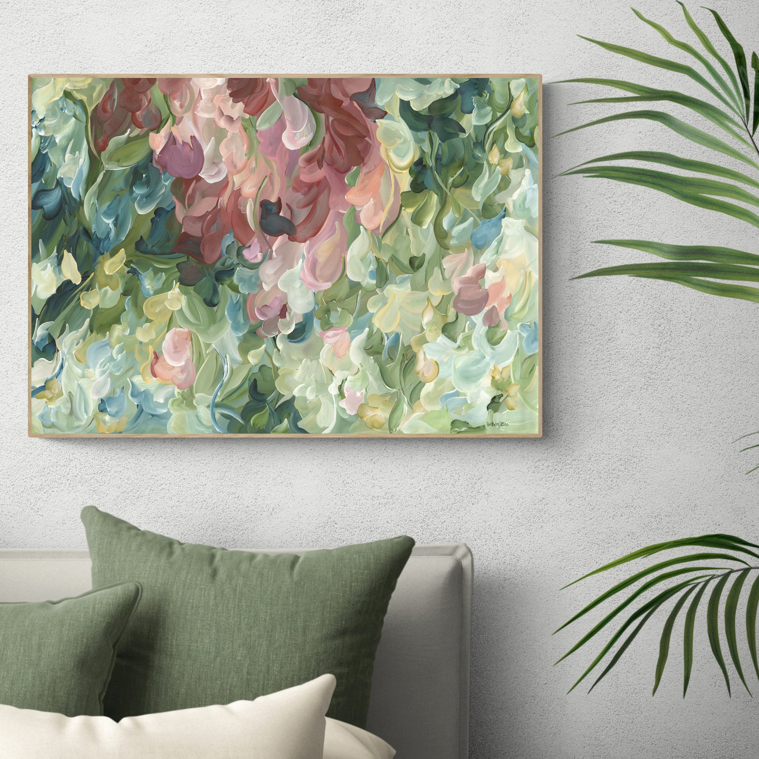 Modern impressionist abstract wall art print of organic round shapes layered like leaves and flower petals falling. Soft pastel green and pinks with pale yellow modern colour palette. Framed in a natural frame and hanging in a contemporary bedroom.