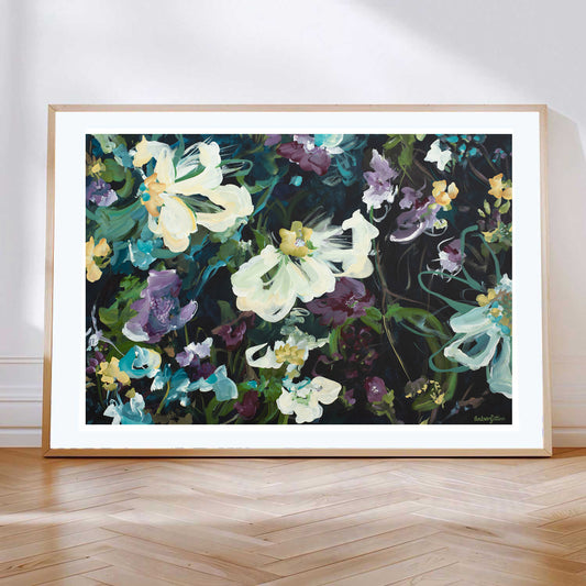 Dark and moody abstract  fine art paper print with purple and white and yellow flowers. With a natural frame leaning against a wall.