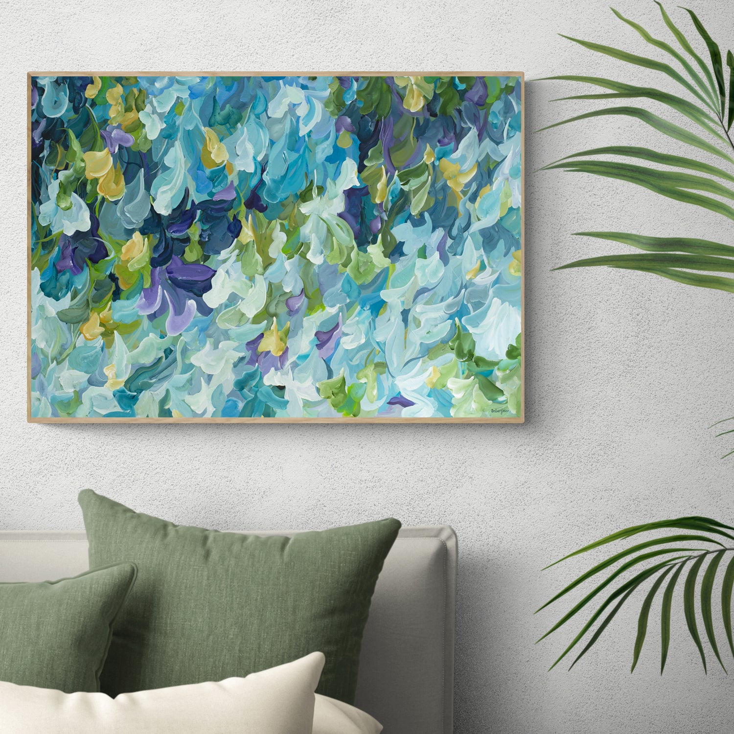 Modern blue, green and purple abstract impressionist canvas art print in a minimal simple style. Falling petals and leaves in a garden. Framed in a natural frame, hanging against a modern neutral bedroom wall.