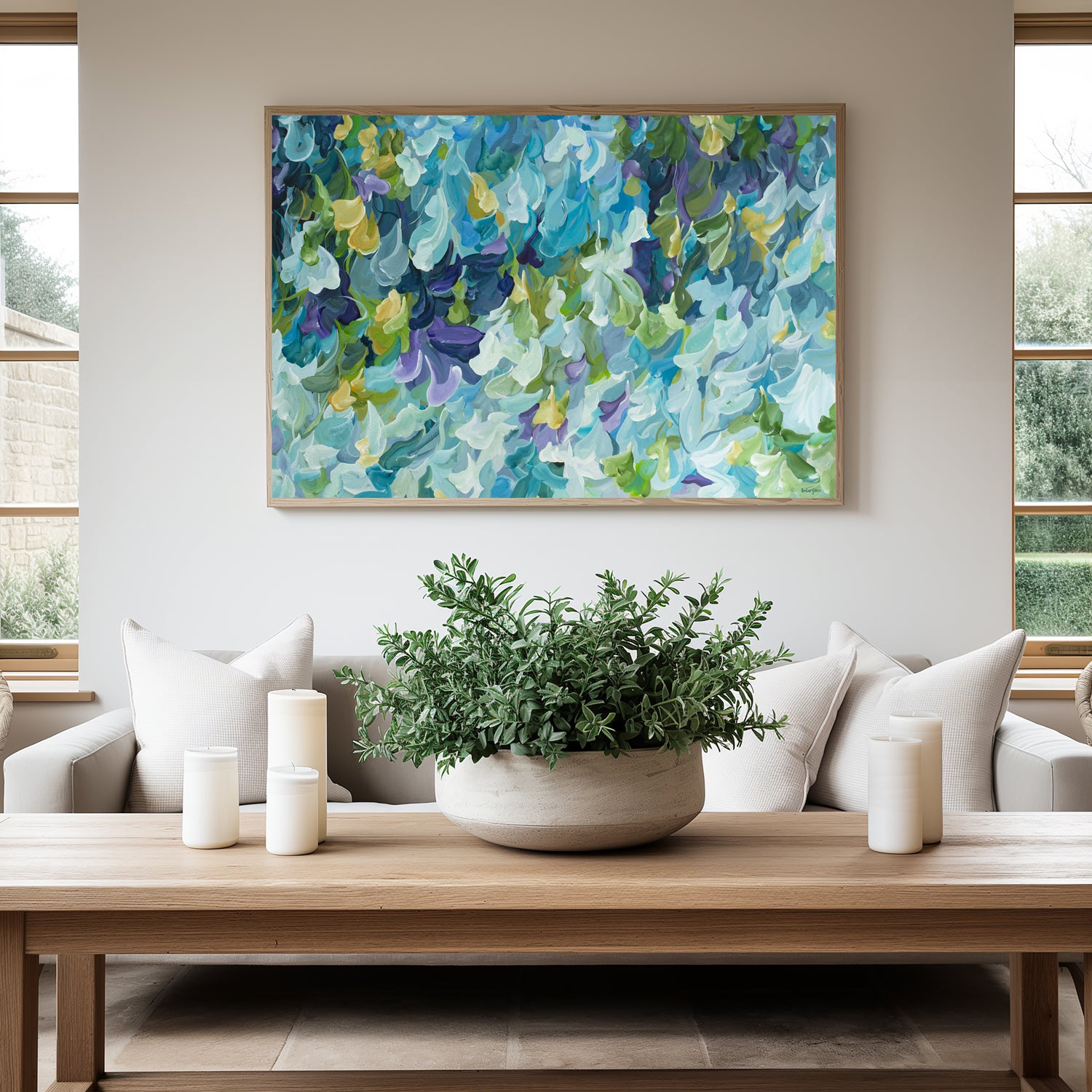 Modern blue, green and purple abstract impressionist wall art print in a minimal simple style. Falling petals and leaves in a garden. Framed in a natural frame, hanging against a modern neutral lounge room wall.