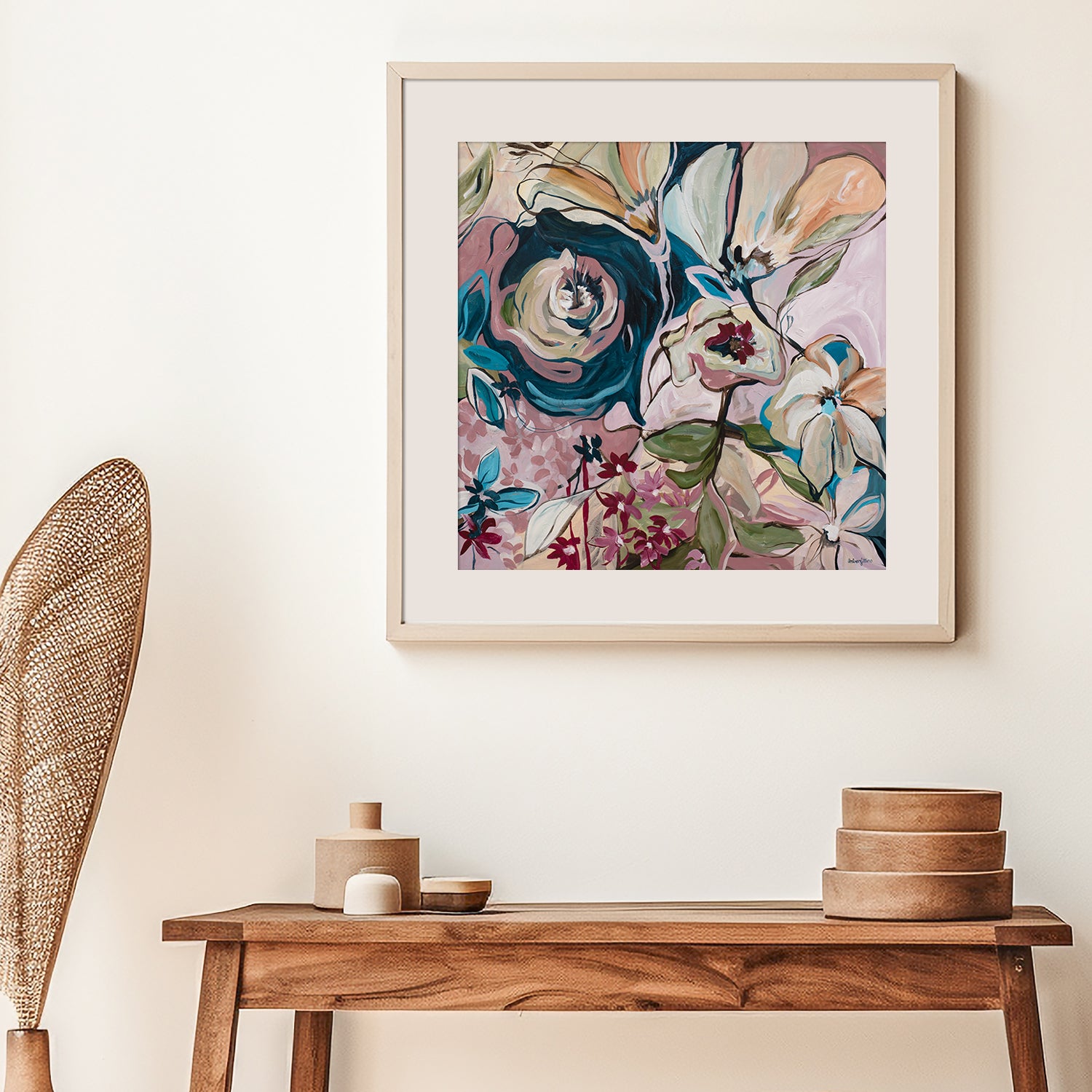 Framed floral art print on a wall above a wooden console table with decorative items.