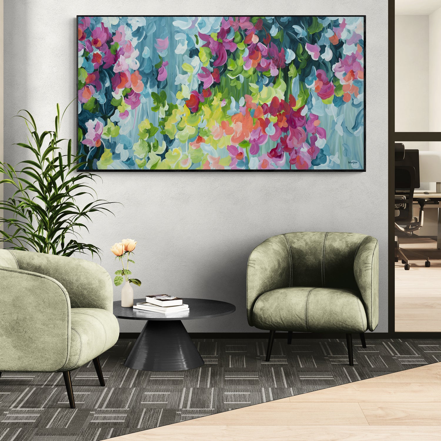 Modern office interior with a colorful floral painting on the wall, green chairs, and a small table.