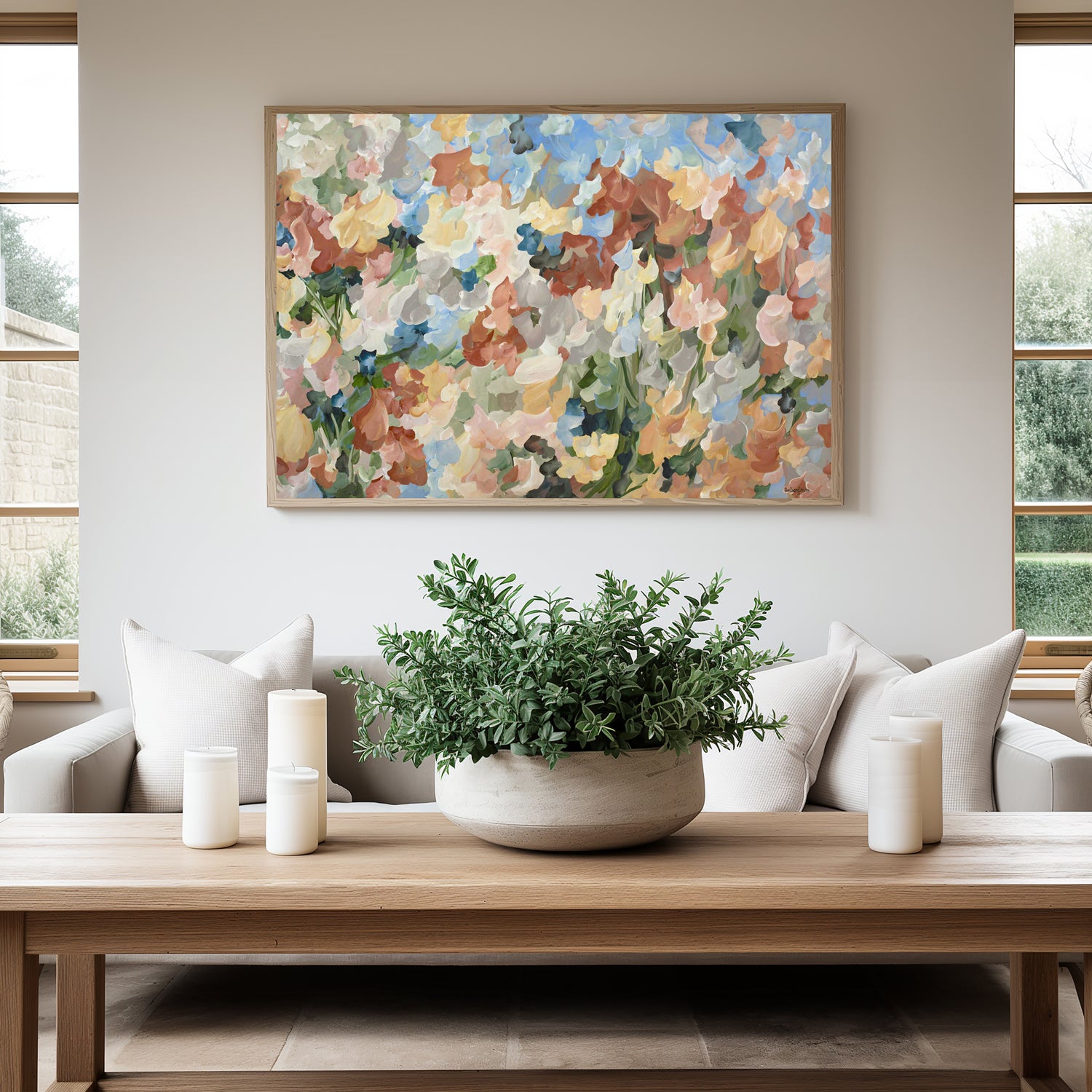 Abstract floral fine art canvas print in soft autumn tones of orange, baby blue, ochre yellow, green. Hanging on a lounge room wall with a natural frame.