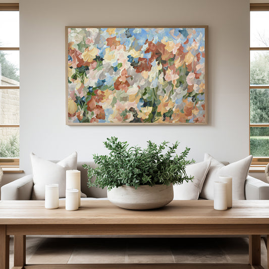 Abstract floral fine art canvas print in soft autumn tones of orange, baby blue, ochre yellow, green. Hanging on a lounge room wall with a natural frame.