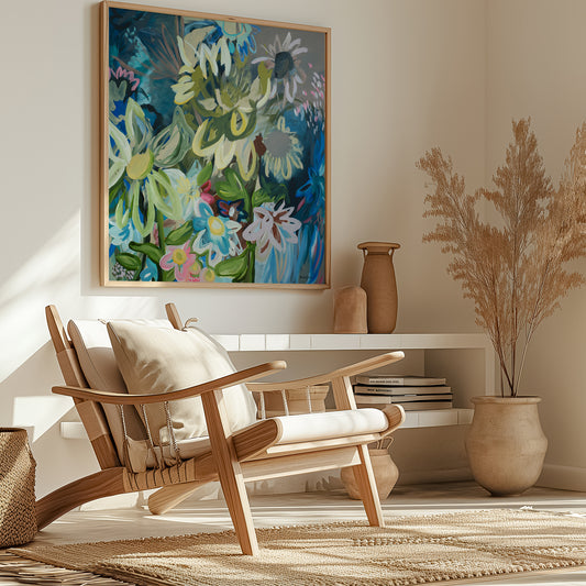 Contemporary square abstract flower fine art print in multi colours. Inspired by sunflowers in the moonlight. Layers of organic flowing shapes and colours in a playful style. Framed in a natural wood frame hanging in a modern living room.