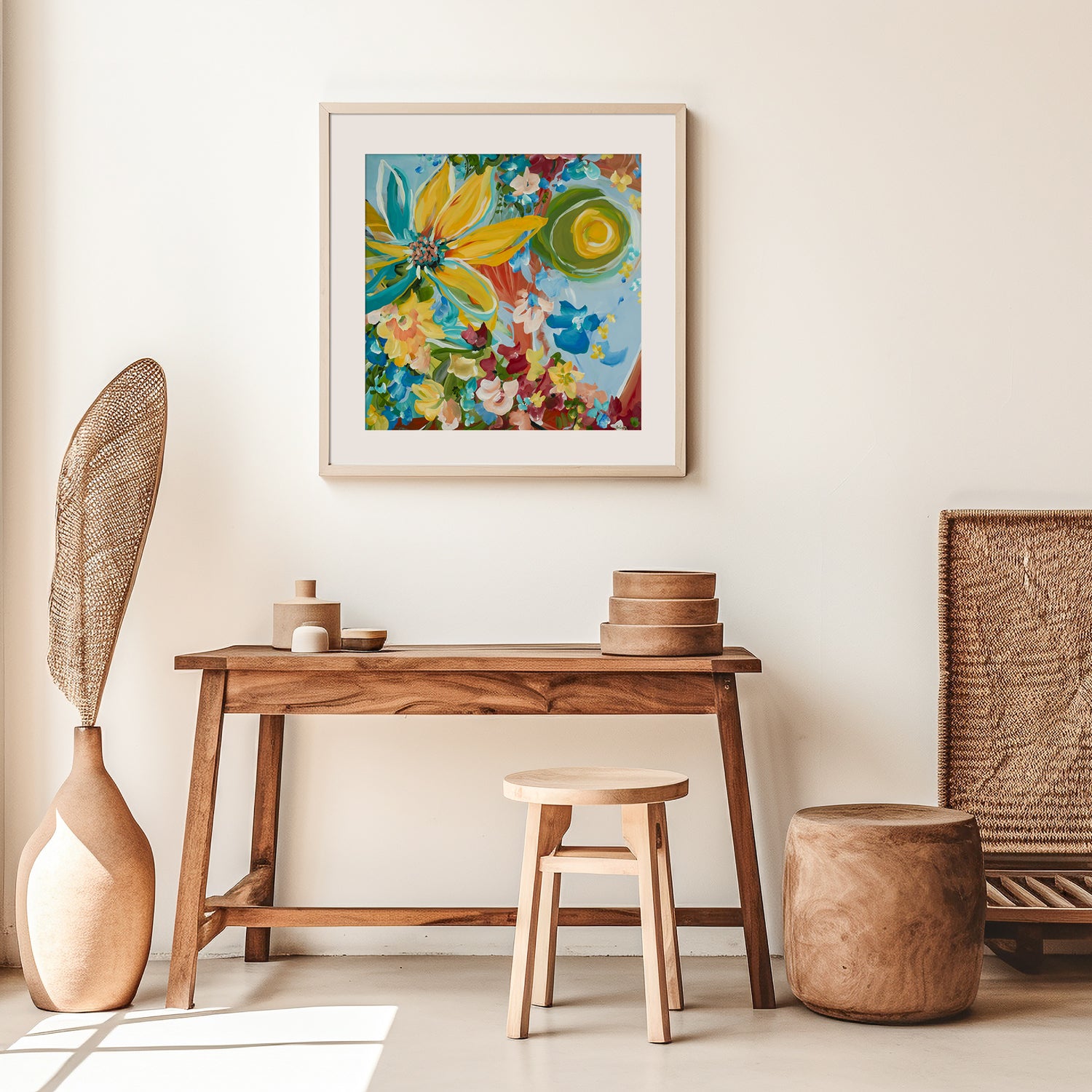 Modern abstract sunflower art print with a big yellow sunflower and smaller red, blue, yellow flowers surrounding it. Colourful wall art print framed in a white frame and hanging in a contemporary neutral living room.