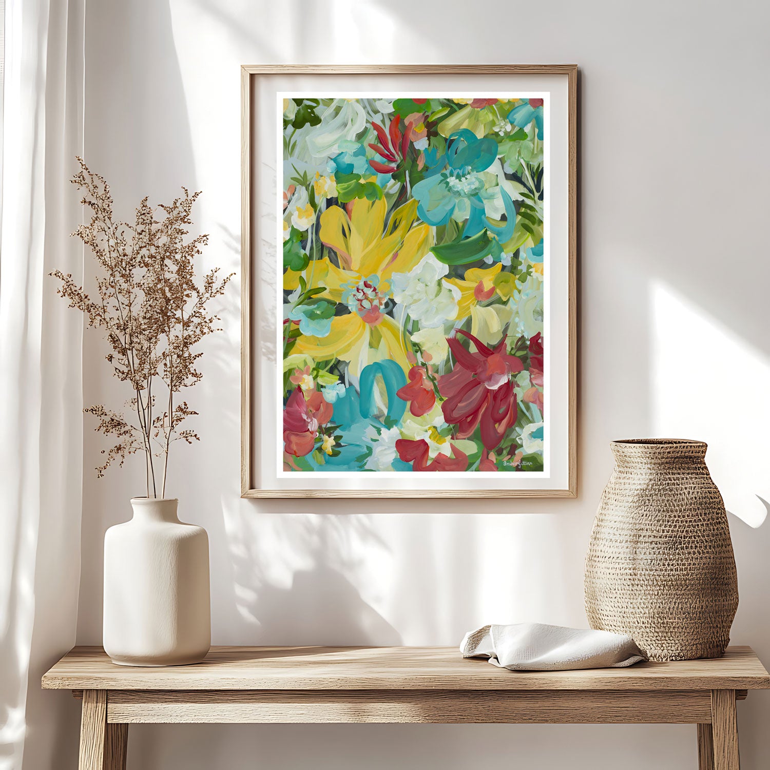 Bold, bright and colourful abstract flower art print in a modern style. Framed in a natural oak frame hnaging against a living room wall.