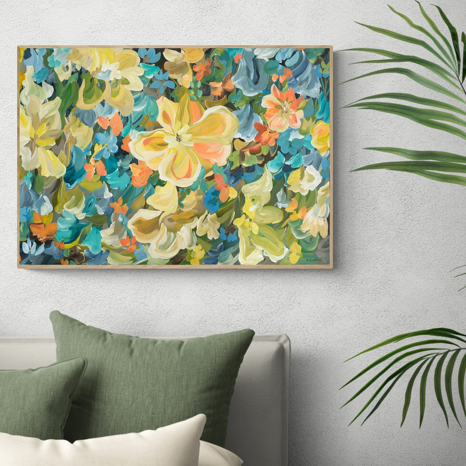 Bright colourful yellow, blue and green tropical flower abstract canvas wall art print. Framed in a natural frame and hanging against a living room wall.