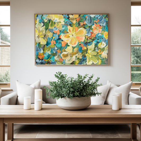 Modern abstract flower canvas art print in bold yellow, blue, orange and green. hanging against a modern neutral living room wall with a natural frame.