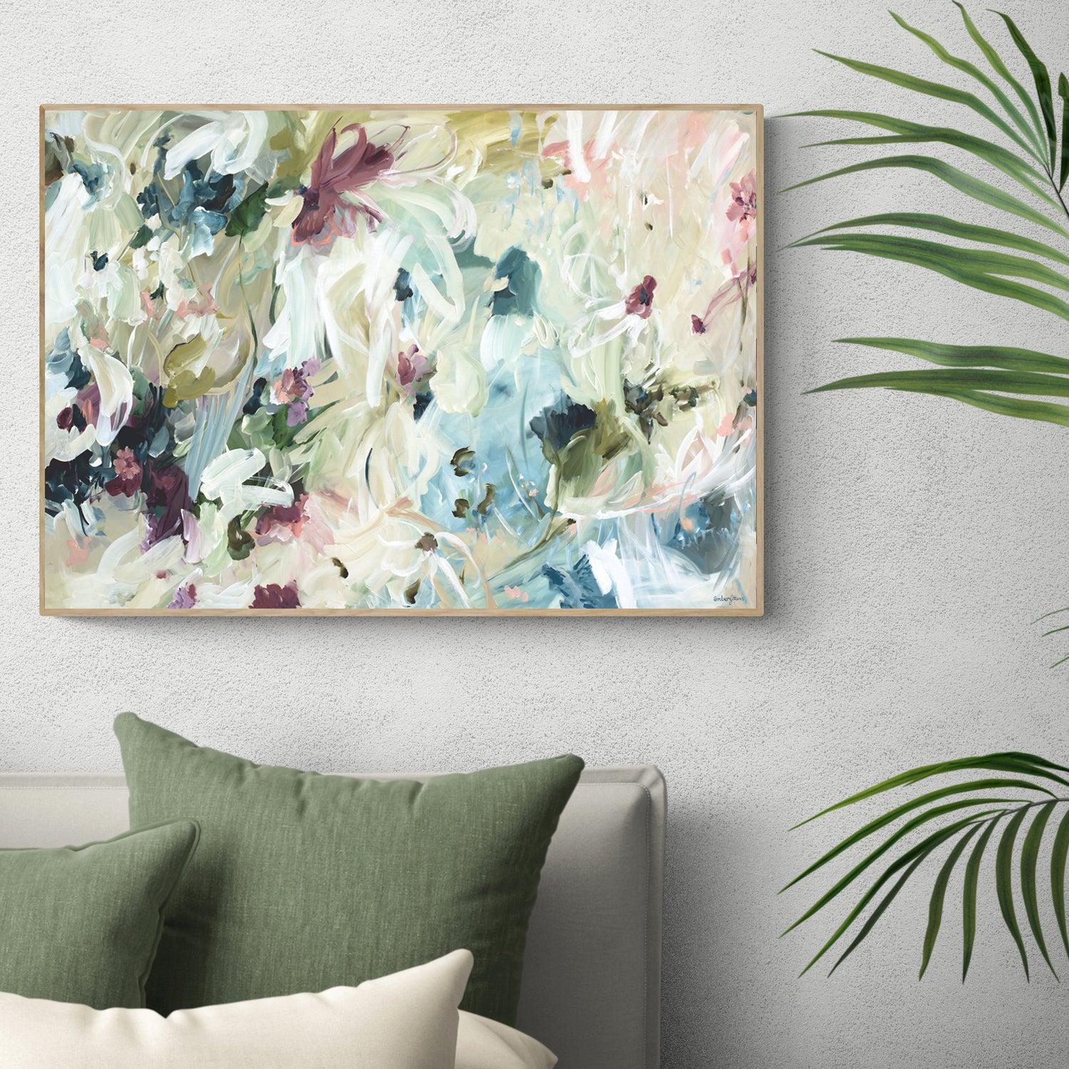 Modern neutral abstract flower wall art print. Minimal and contemporary style in beige, creams, with hints of green, turquoise and burgundy. Framed canvas print in a natural frame hanging against a contemporary bedroom wall.