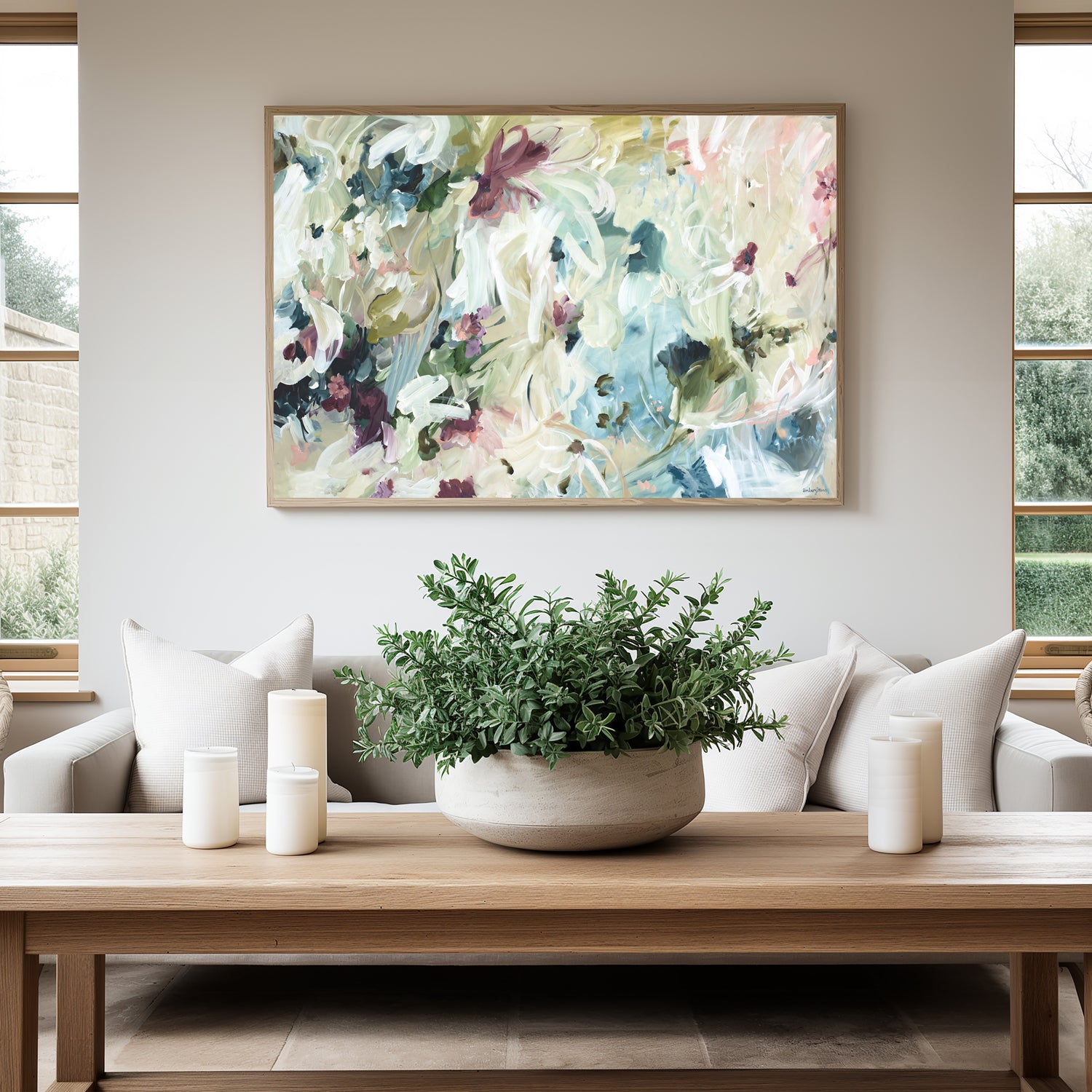 Modern neutral abstract flower wall art print. Minimal and contemporary style in beige, creams, with hints of green, turquoise and burgundy. Framed canvas print in a natural frame hanging against a contemporary living room wall.