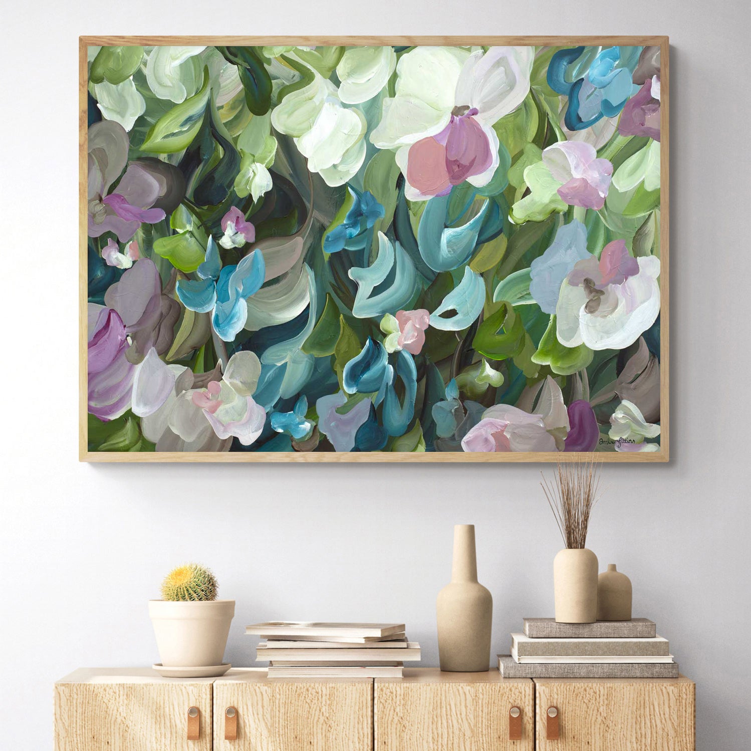 colourful green, turquoise, pink abstract botanical fine art canvas print hanging on a living room wall with a natural frame.