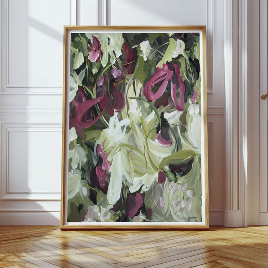 Modern wildflower abstract wall art print in contemporary colour palette of burgundy, white and green. Expressive organic flowing petal and leave shapes in layers. Framed wall art print in a natural frame leaning against a living room wall.