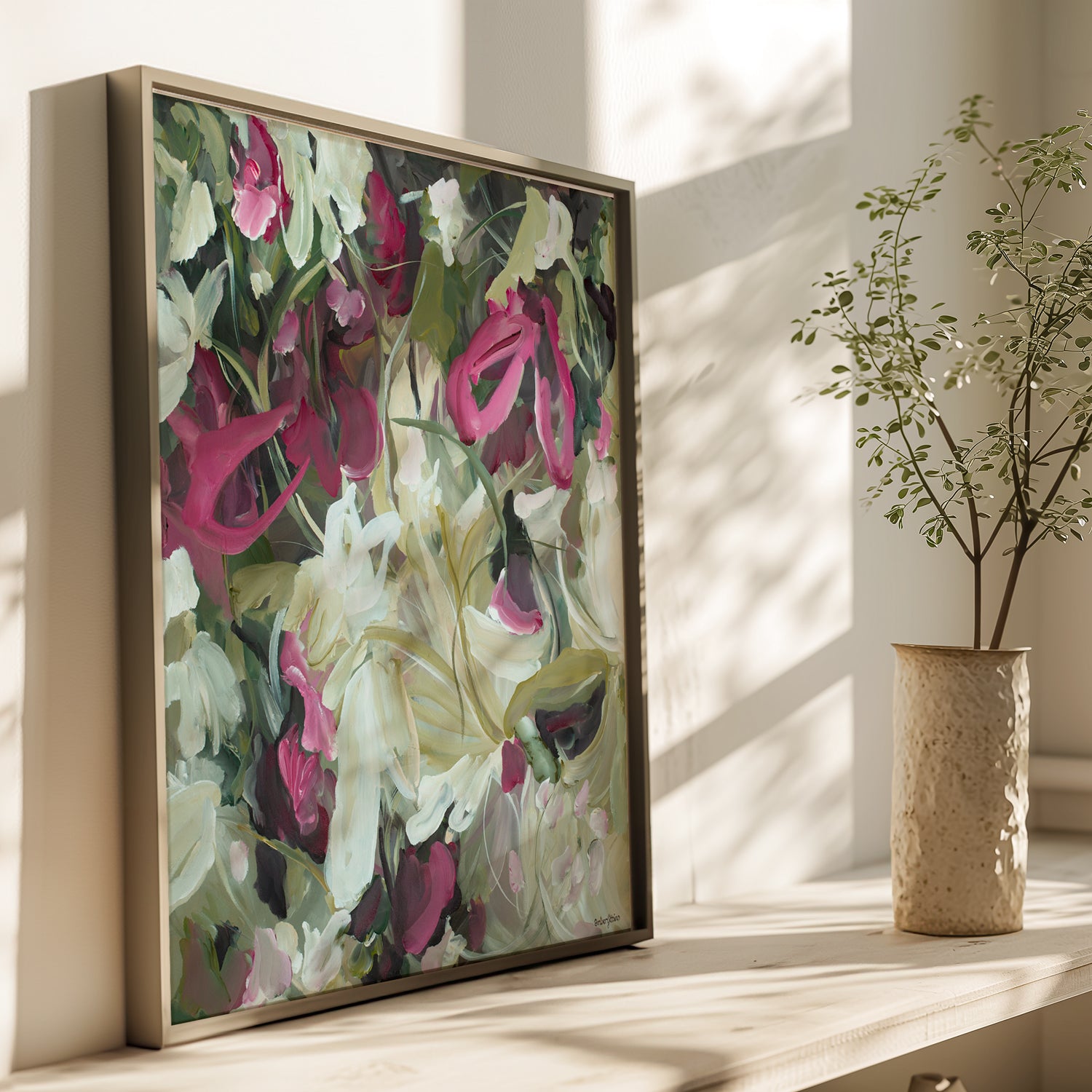 Modern wildflower abstract wall art print in contemporary colour palette of burgundy, white and green. Expressive organic flowing petal and leave shapes in layers. Framed wall art print in a natural bronze frame leaning on a cupboard in a home.