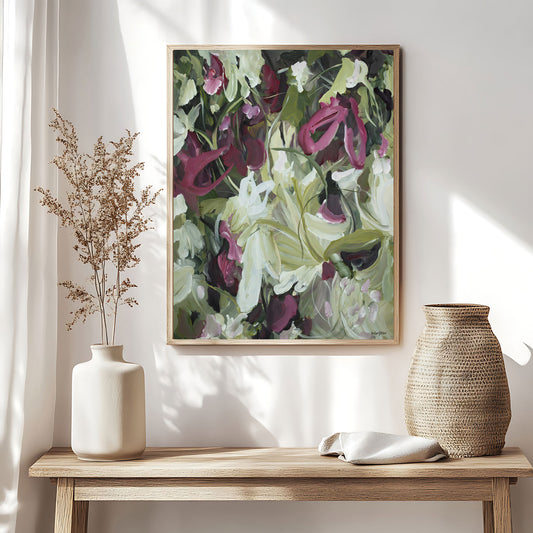 Modern wildflower abstract wall art print in contemporary colour palette of burgundy, white and green. Expressive organic flowing petal and leave shapes in layers. Framed wall art print in a natural frame hanging against a modern neutral living room wall.