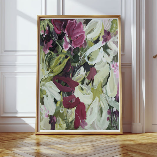 Modern wildflower fine art print in an expressive style in modern colour palette of burgundy, white and green. Abstract floral flowing shapes layered over each other. Framed in a natural frame and leaning against a living room wall.
