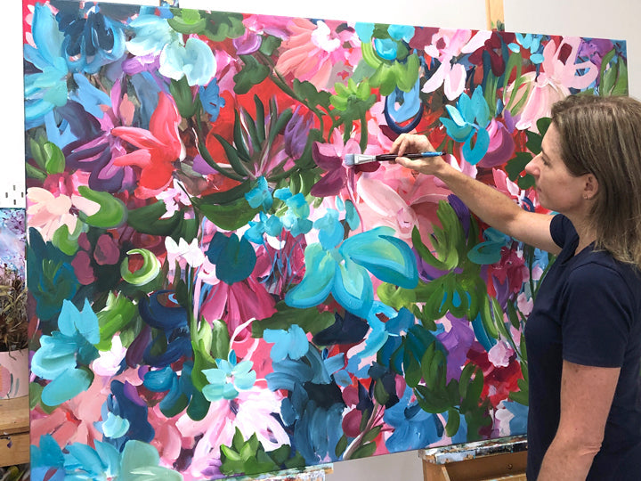 Artist Amber Gittins painting a colourful flower abstract 