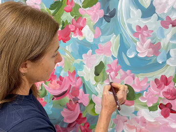 Artist Amber Gittins in her art studio with a flower abstract original painting