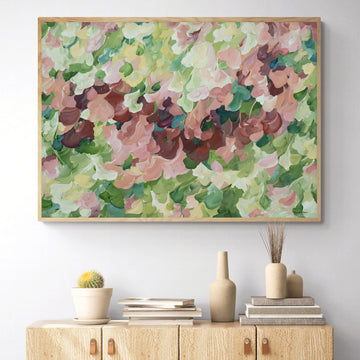 Modern nature art print in contemporary colours of warm brown and pinks and natures green. Contemporary impressionist simple style. Framed in a natural frame and hanging against a living room wall.