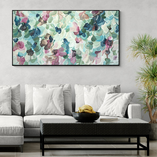 Living room with a colorful abstract painting on the wall, white sofa, and coffee table with bananas.