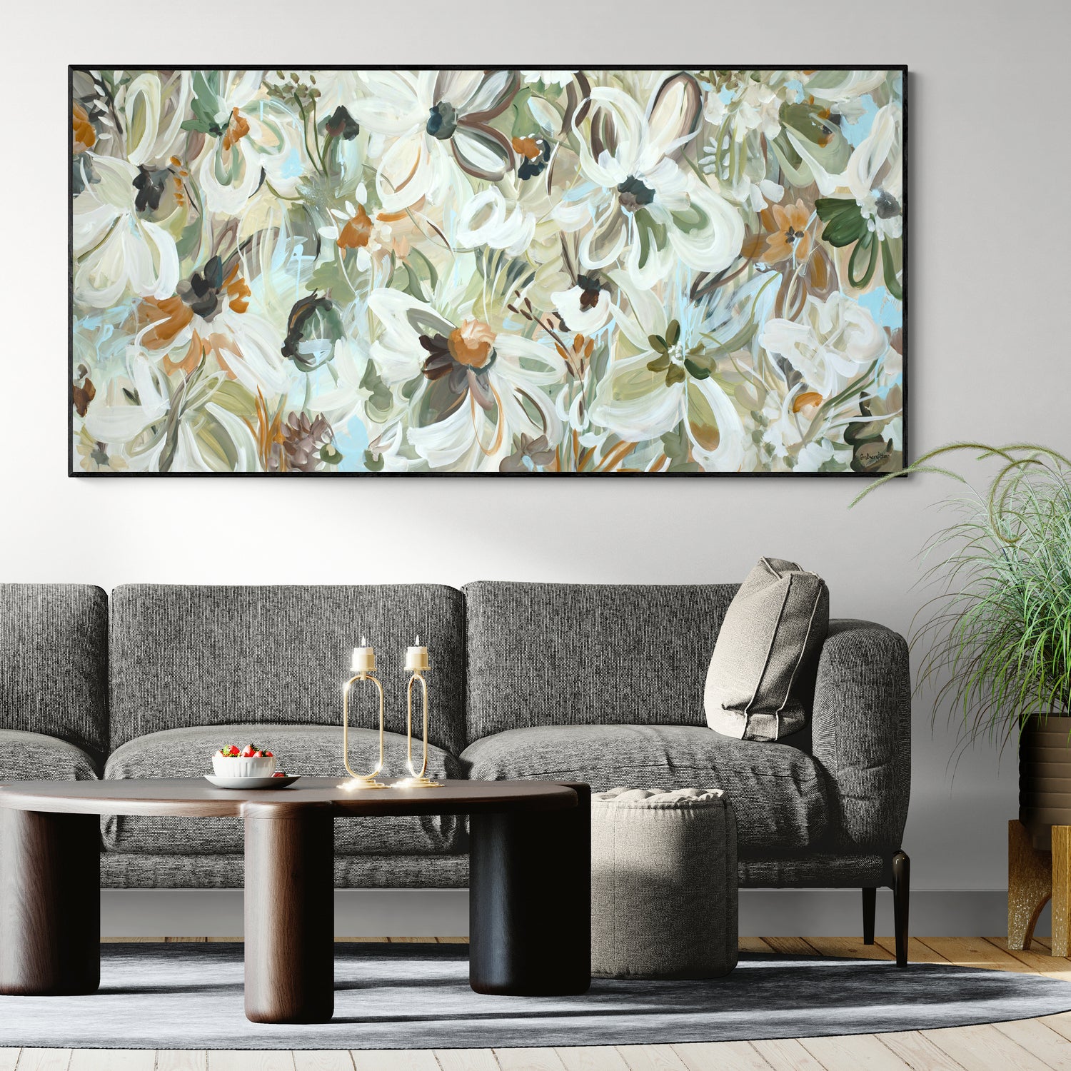 Living room with a gray sofa, coffee table, and floral painting on the wall.