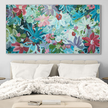 Modern blue, pink and red abstract flower painting. Large art hanging in a bedroom setting.