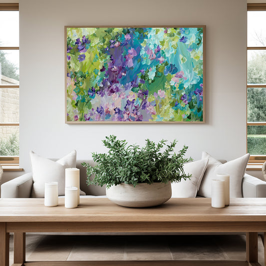 Colourful blue, green and purple abstract flower  fine art canvas print hanging in a neutral living room with a white lounge.