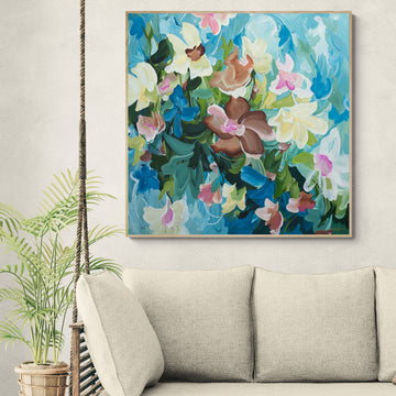 Colorful floral painting above a beige sofa in a living room.