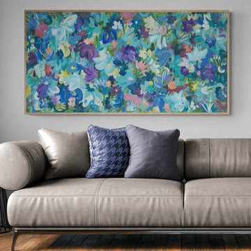 Colourful blue and purple abstract flower fine art print. Layers of flower petals and leaves in a modern impressionist style. Framed in a natural frame in a living room.