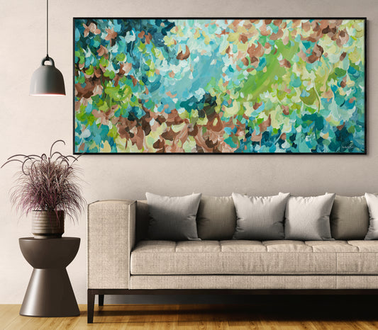 Living room with a gray sofa, decorative plant, and colorful abstract painting on the wall.